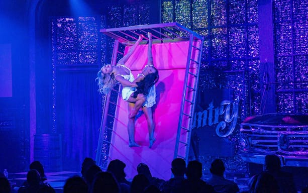Performers on stage during Kick'n Topless Revue in Vegas, featuring acrobatic dance.