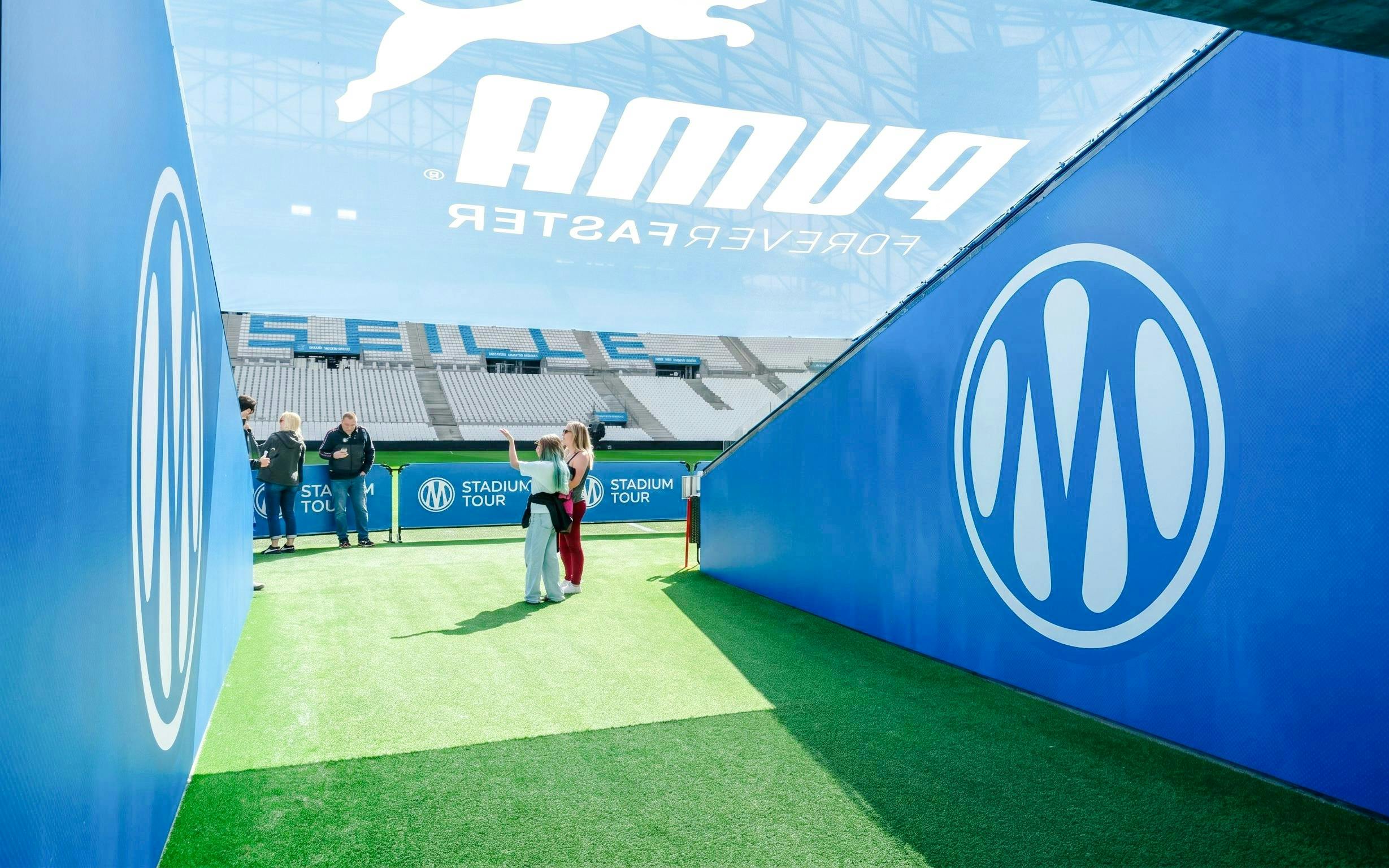 Visitors exploring OM Stadium entrance during a tour in Marseille.