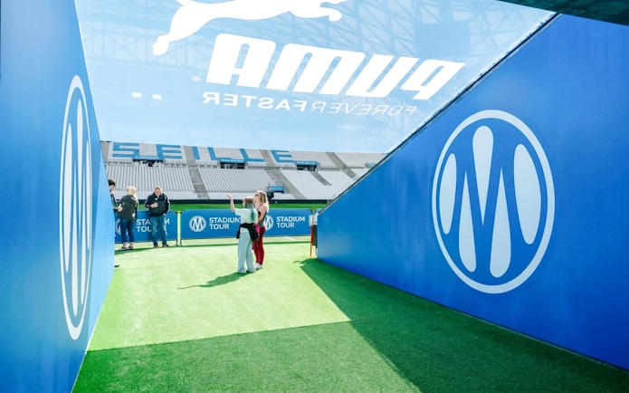 Visitors exploring OM Stadium entrance during a tour in Marseille.