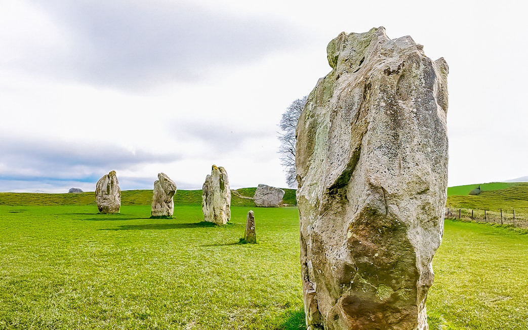 Avebury stone circle in a green field, part of a full-day tour from London.