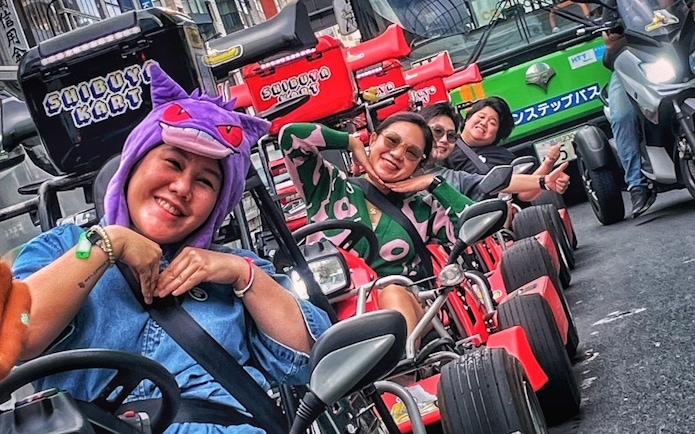 Go-kart riders in costume enjoying Shibuya Kart tour through Tokyo streets.