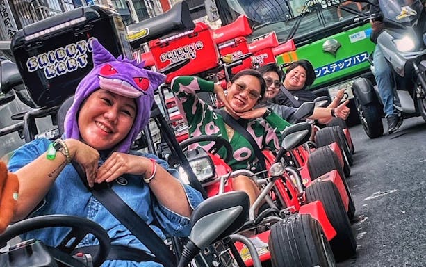 Go-kart riders in costume enjoying Shibuya Kart tour through Tokyo streets.