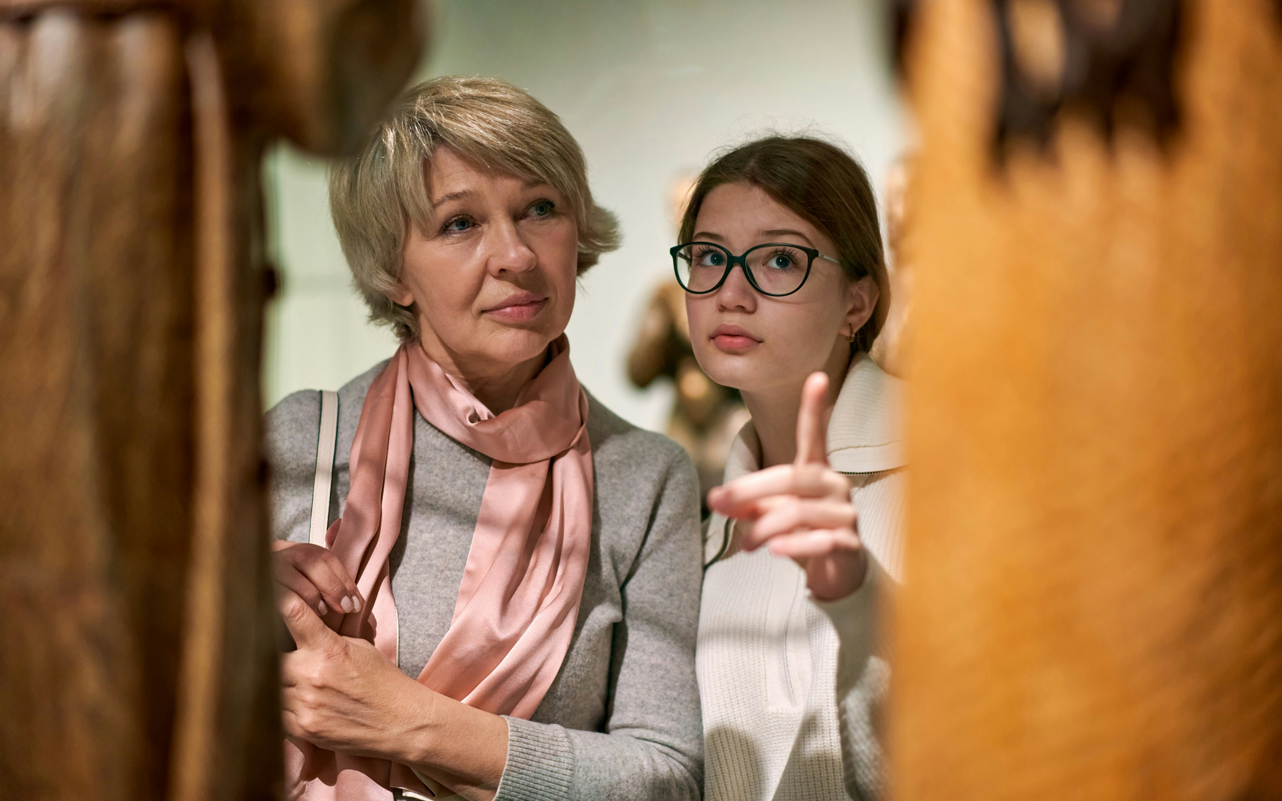 Visitors observing wax figures in a museum exhibit.
