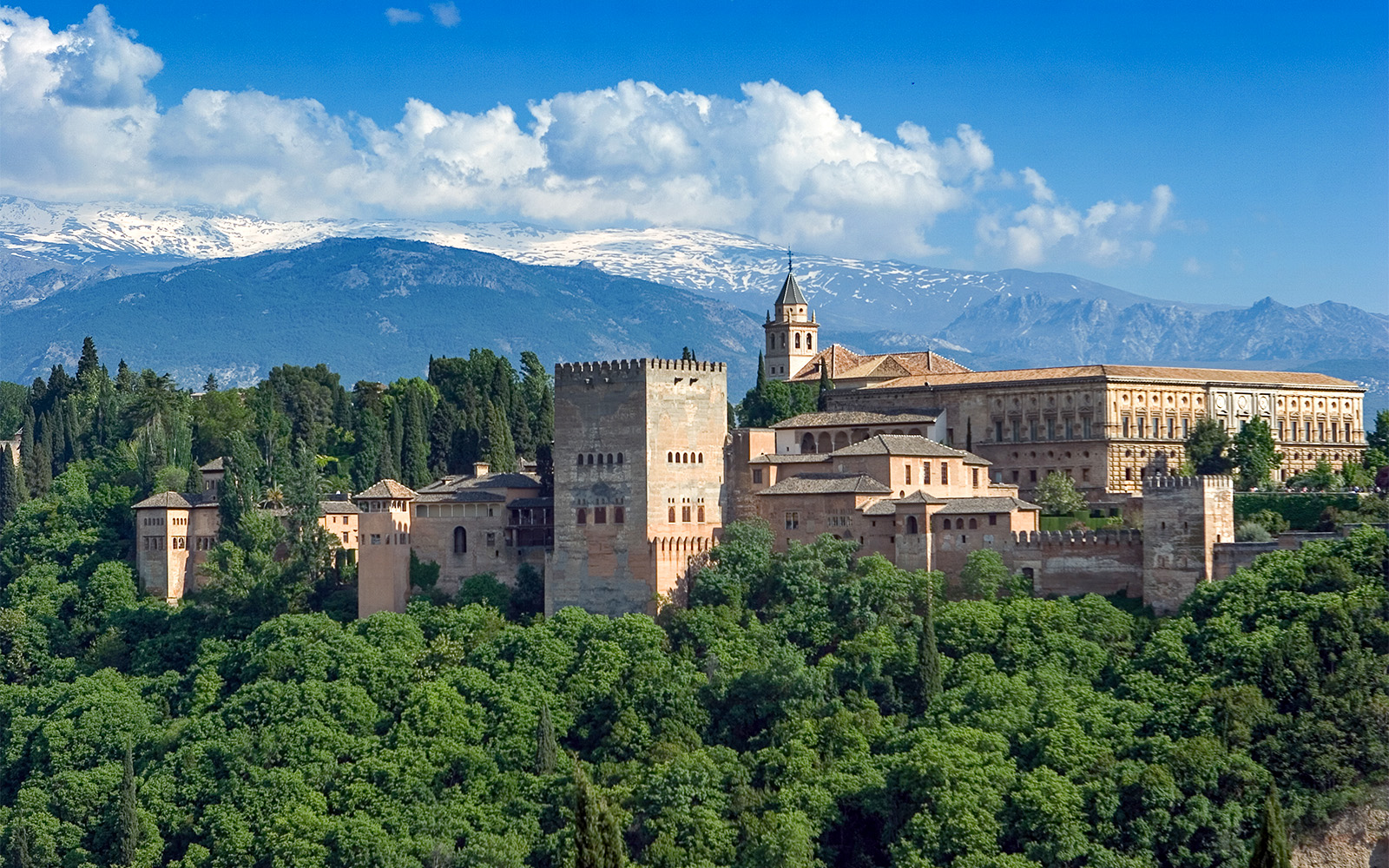 Palace of Generalife gardens with fountains and lush greenery in Granada, Spain.