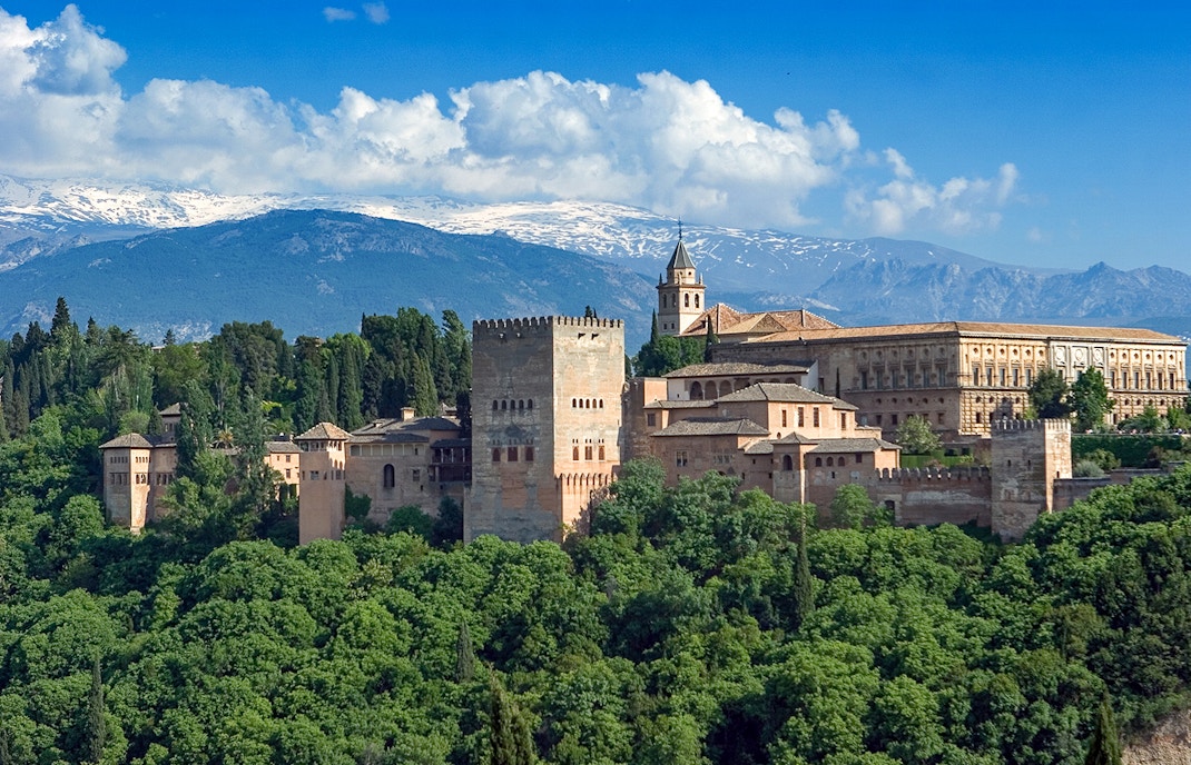 Palace of Generalife gardens with fountains and lush greenery in Granada, Spain.