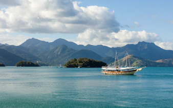 Schooner sailing in Angra dos Reis bay with Ilha Grande mountains, Rio de Janeiro, Brazil.