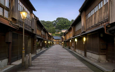 Traditional wooden street in Kanazawa, Japan, illuminated by lanterns at dusk.