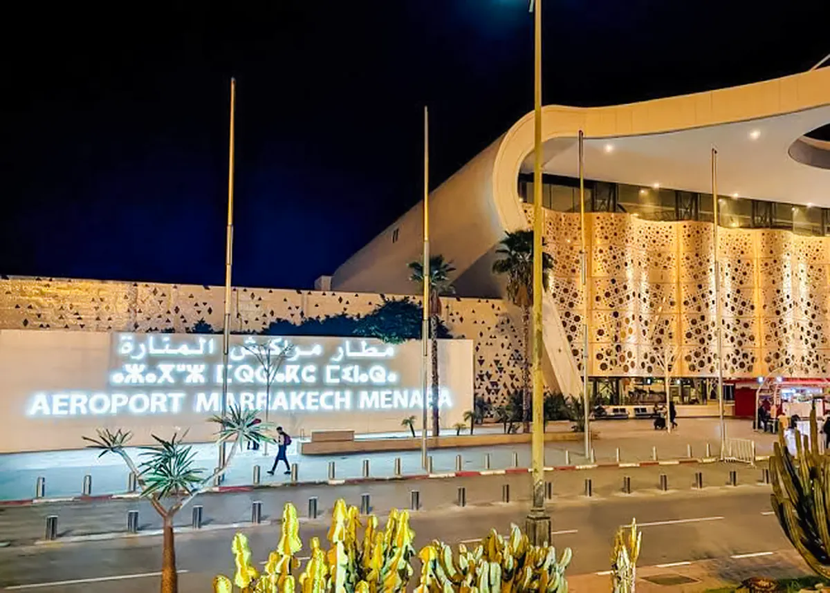 Marrakech Menara Airport entrance at night, featuring modern architecture and illuminated signage.