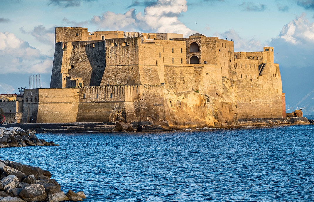 Castel dell'Ovo on the Gulf of Naples with boats in the foreground, Naples, Italy.