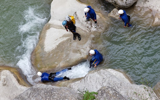Canyoning group navigating rocks and water in Chli Schliere near Interlaken.