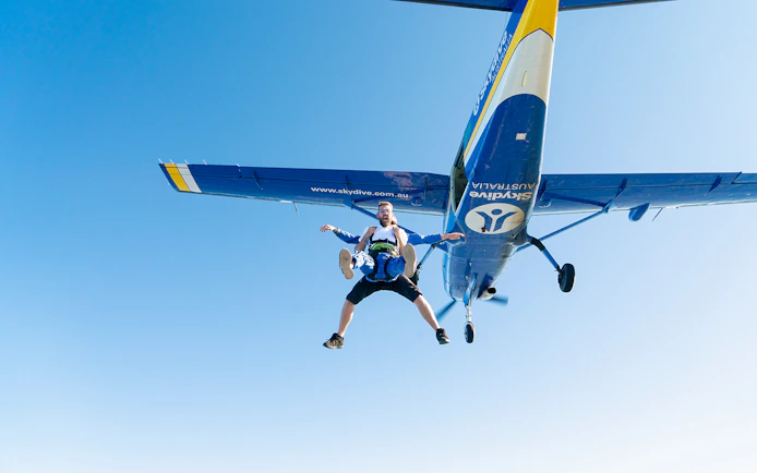 Skydivers in tandem freefall from plane over Wollongong, Sydney.