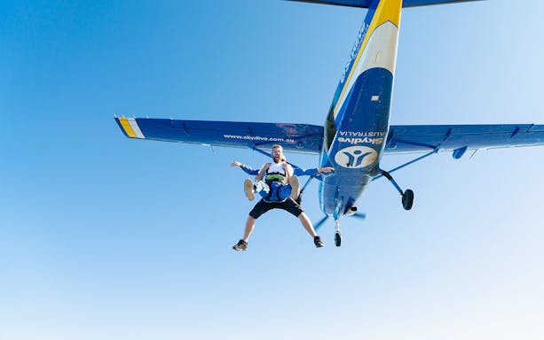 Skydivers in tandem freefall from plane over Wollongong, Sydney.
