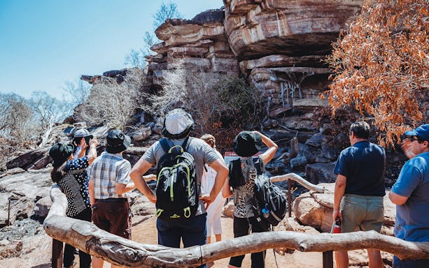 Tourists exploring rock formations on Kakadu Public Day Tour, Australia.