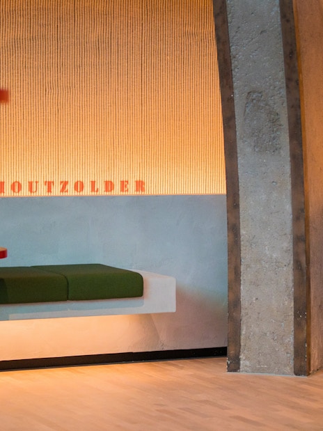 Heineken Rooftop Experience seating area with green benches and red tables.