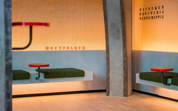 Heineken Rooftop Experience seating area with green benches and red tables.