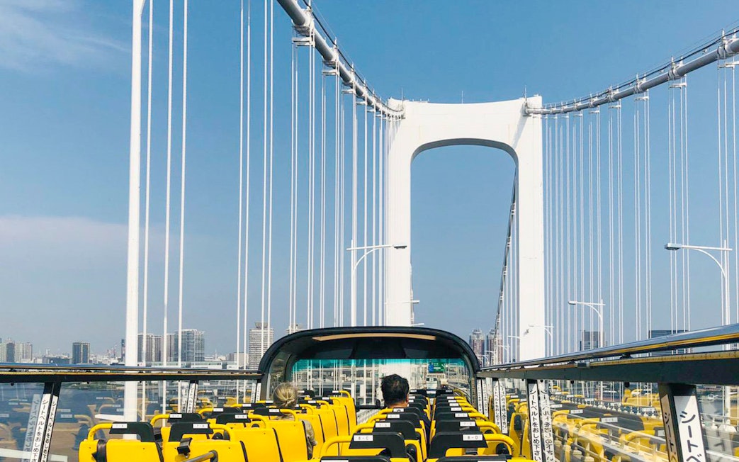 Open-top bus crossing Rainbow Bridge in Tokyo.