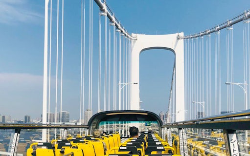 Open-top bus crossing Rainbow Bridge in Tokyo.