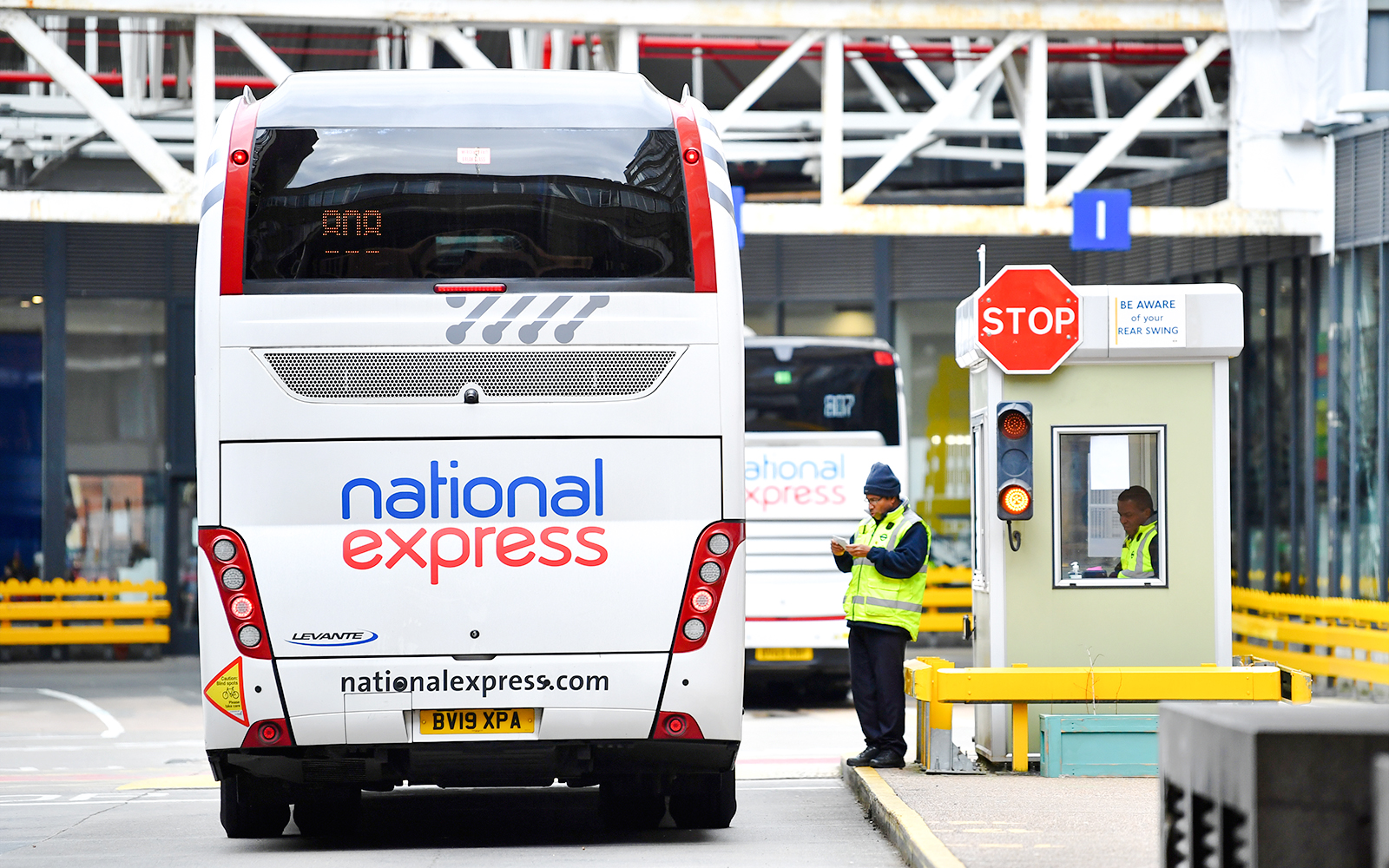 Bus at London Victoria Station with staff managing transfers.