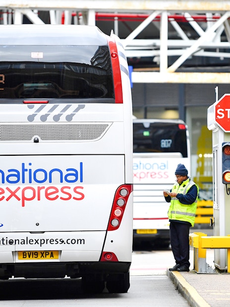 Bus at London Victoria Station with staff managing transfers.