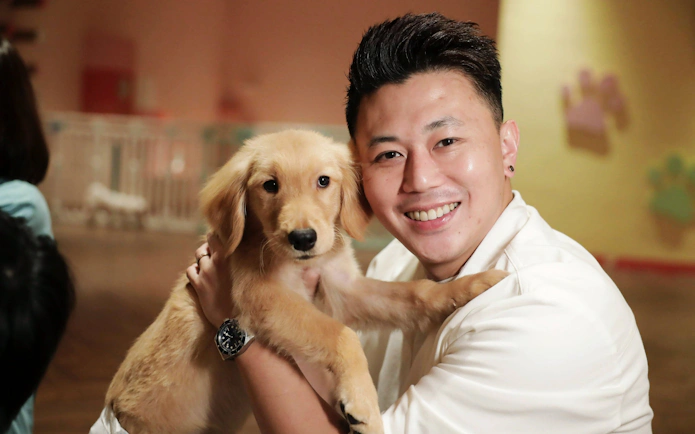 Man holding a puppy at Just Pets Megastore.