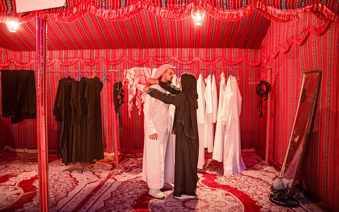 Traditional clothing fitting in Abu Dhabi desert safari tent.