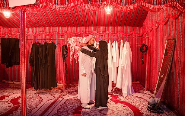 Traditional clothing fitting in Abu Dhabi desert safari tent.