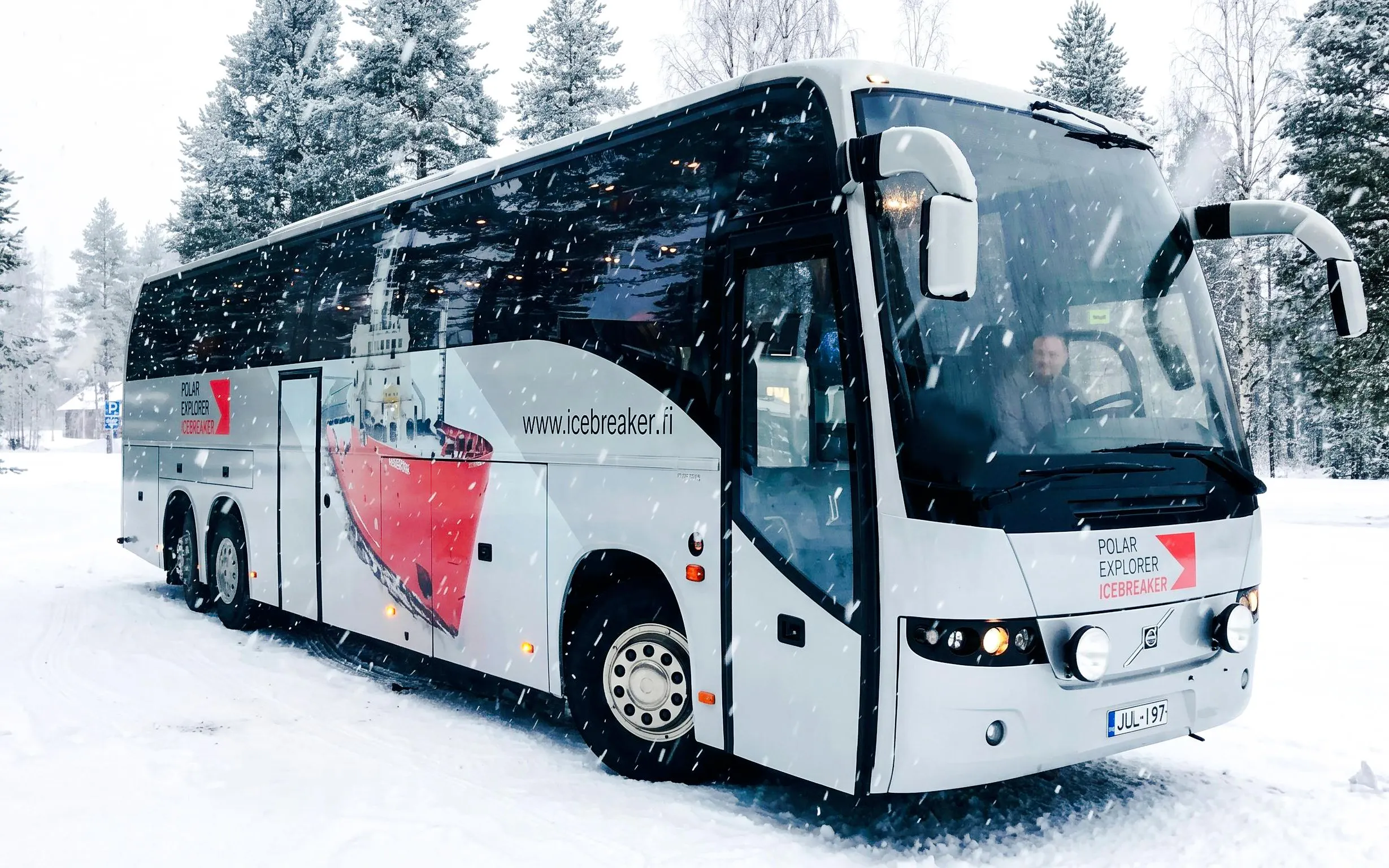 Bus used for transfers during Icebreaker Cruise & Ice Floating Experience in snowy landscape.