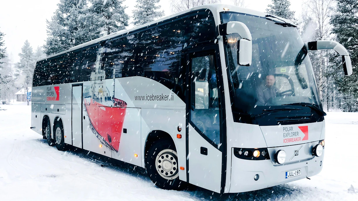Bus used for transfers during Icebreaker Cruise & Ice Floating Experience in snowy landscape.