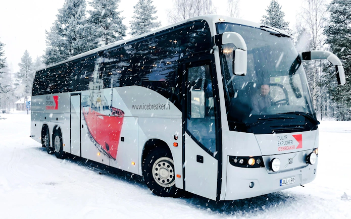 Bus used for transfers during Icebreaker Cruise & Ice Floating Experience in snowy landscape.
