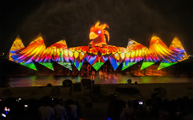 Wings of Time night show with colorful lights and bird projection at Sentosa Island.
