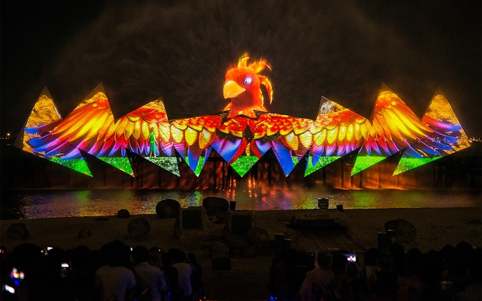 Wings of Time night show with colorful lights and bird projection at Sentosa Island.