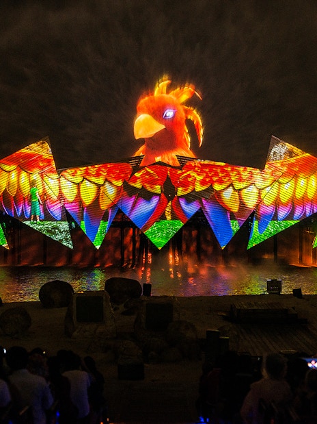 Wings of Time night show with colorful lights and bird projection at Sentosa Island.