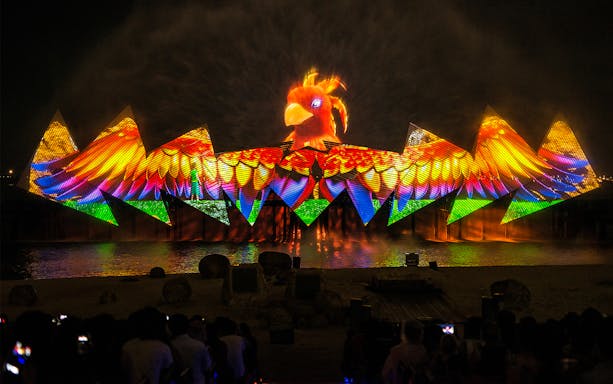 Wings of Time night show with colorful lights and bird projection at Sentosa Island.