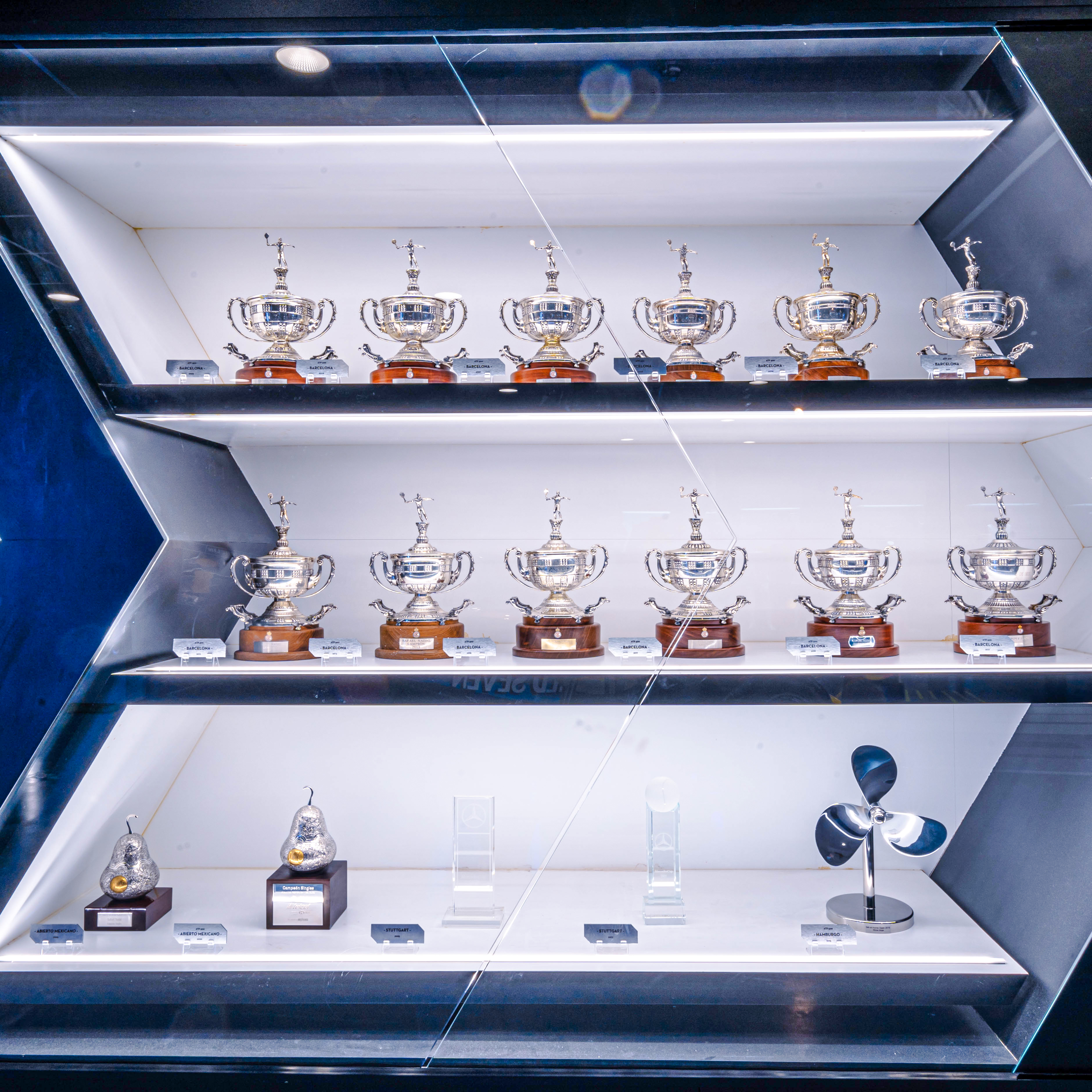 Trophy cabinet at Rafa Nadal Museum Xperience displaying tennis awards in Mallorca, Spain.