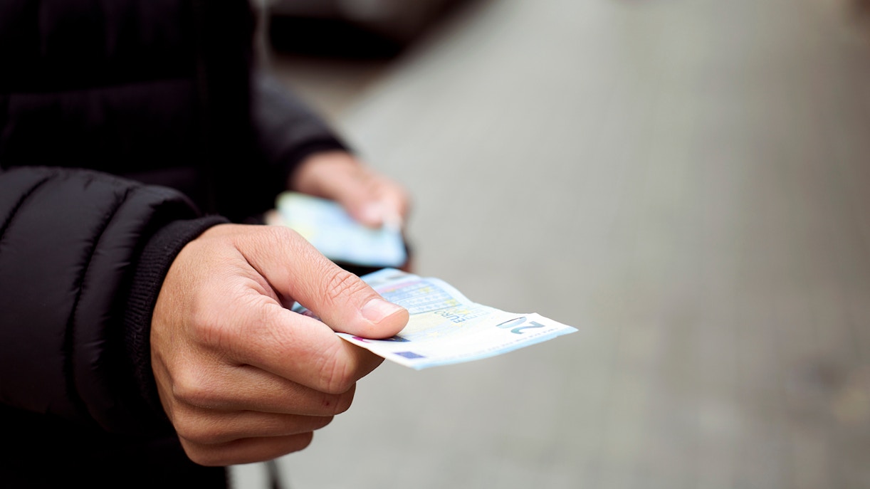 man paying cash for quick coffee