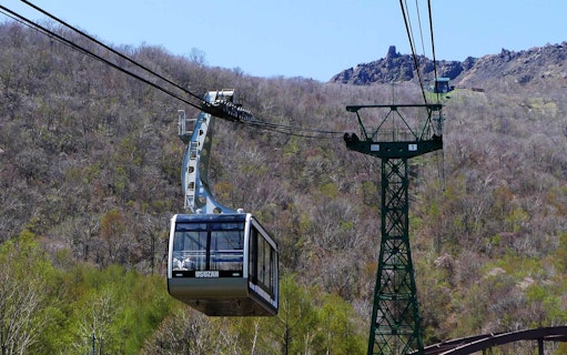 Mt. Usu cable car ascending over forested landscape in Japan.