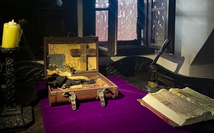 Bran Castle interior with a vampire hunting kit and ancient book on a table.
