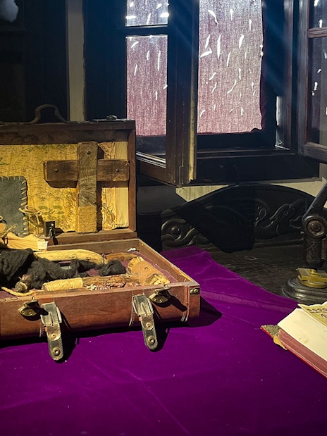 Bran Castle interior with a vampire hunting kit and ancient book on a table.