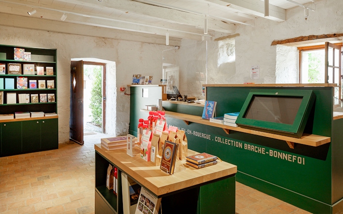Beaulieu-en-Rouergue Abbey gift shop with books and souvenirs displayed.