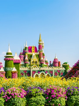 Floral castle display at Dubai Miracle Garden with vibrant flowers and towers.