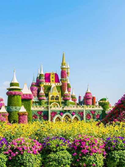 Floral castle display at Dubai Miracle Garden with vibrant flowers and towers.
