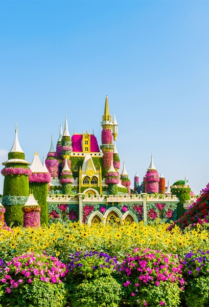 Floral castle display at Dubai Miracle Garden with vibrant flowers and towers.