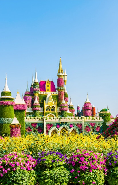 Floral castle display at Dubai Miracle Garden with vibrant flowers and towers.