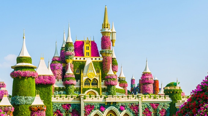 Floral castle display at Dubai Miracle Garden with vibrant flowers and towers.