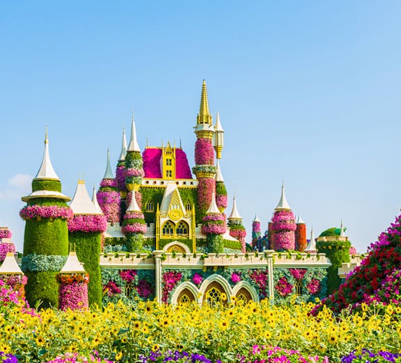 Floral castle display at Dubai Miracle Garden with vibrant flowers and towers.