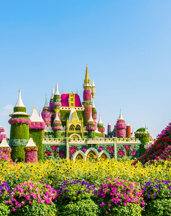 Floral castle display at Dubai Miracle Garden with vibrant flowers and towers.
