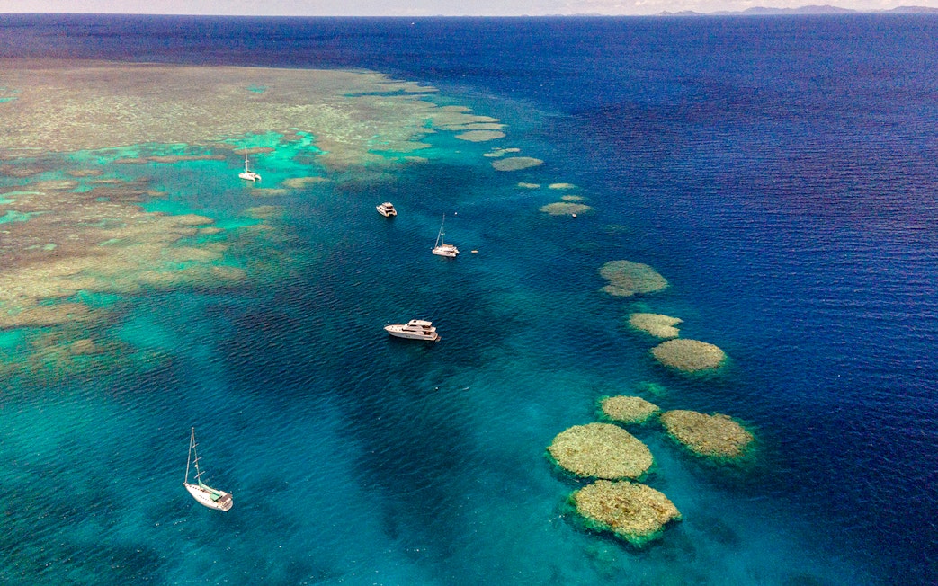 Small boats sailing near coral reefs in the Great Barrier Reef, Cairns.