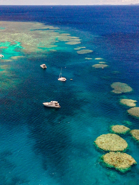 Small boats sailing near coral reefs in the Great Barrier Reef, Cairns.