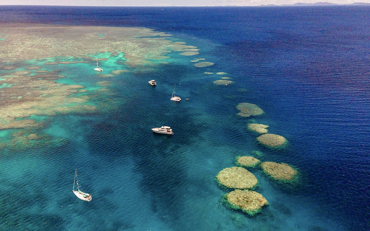 Small boats sailing near coral reefs in the Great Barrier Reef, Cairns.