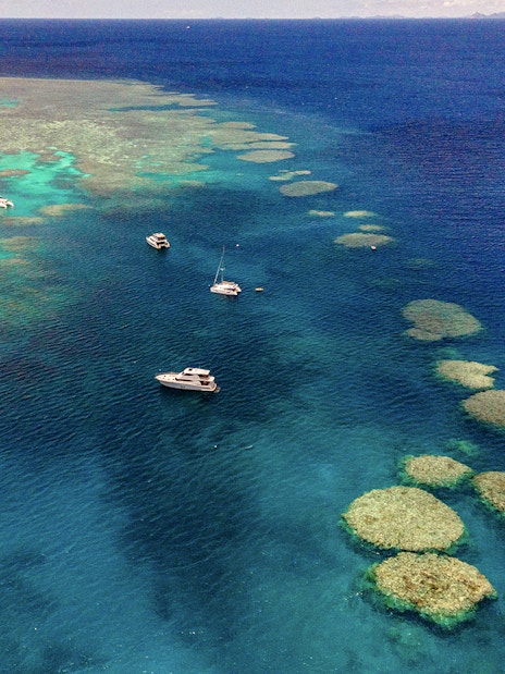 Small boats sailing near coral reefs in the Great Barrier Reef, Cairns.